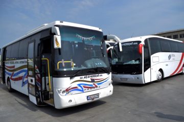 Două autocare albe, vedere din față și lateral