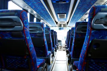 Interior autocar cu scaune albastre și culoar central