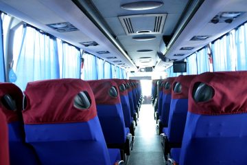 Interior autocar cu scaune albastre și tetiere roșii