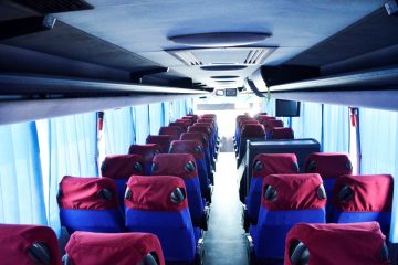 Interior autocar cu scaune albastre, huse roșii și ecran