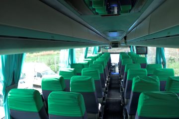 Interior autocar cu scaune verzi și ecran