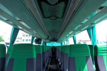 Interior autocar cu scaune verzi și gri și ecran