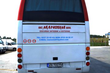 Autocar alb cu roșu văzut din spate