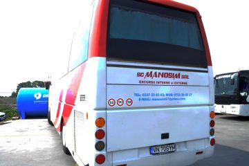 Autocar alb cu roșu văzut din spate