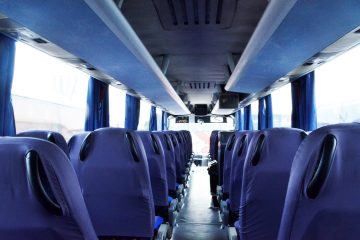 Interior autocar cu scaune albastre și ecrane