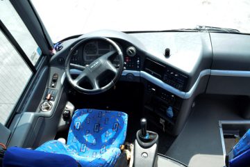 Interior de autocar cu bord, volan și scaun albastru