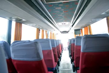 Interior autocar cu scaune roșii, huse gri și ecran