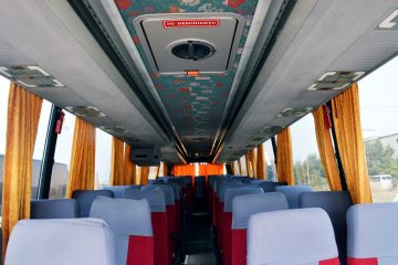 Interior autocar cu scaune gri și perdele galbene