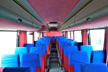 Interior de autocar cu scaune albastre și roșii