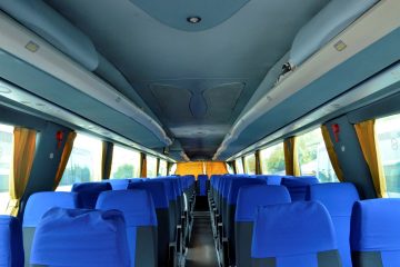 Interior autocar cu scaune albastre și perdele galbene