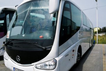 Autocar alb văzut din față și lateral