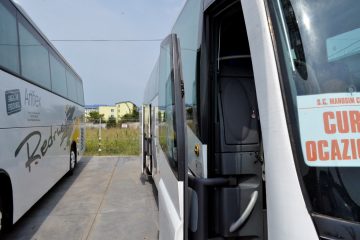Autocar alb văzut din față lateral cu ușa deschisă