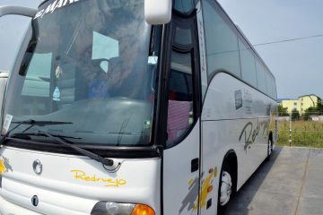 Autocar alb văzut din față și lateral stânga