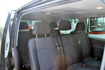 Interior microbuz cu scaune negre și centuri de siguranță