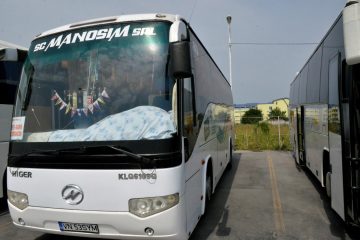 Autocar alb văzut din față și lateral